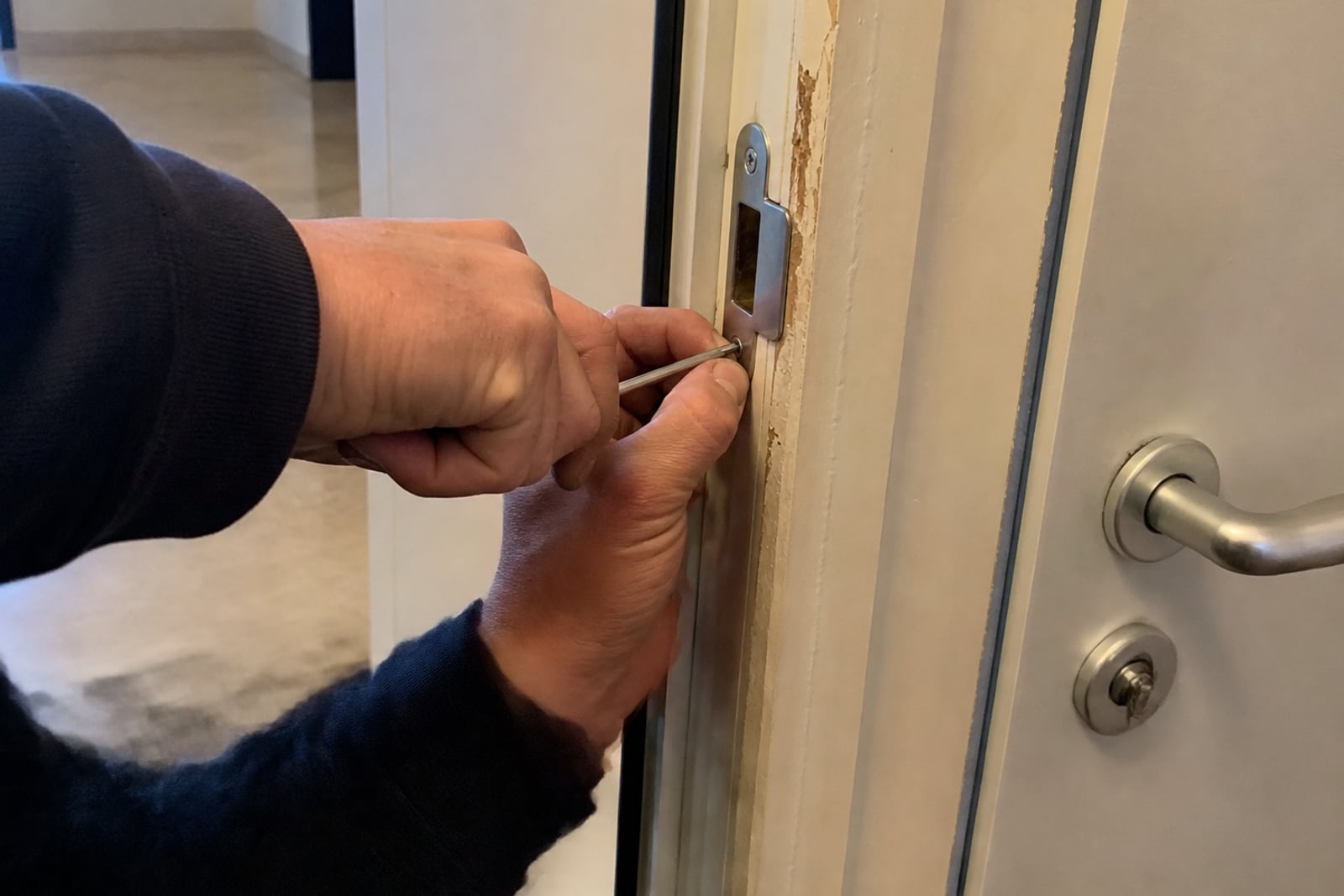 mains réglant gâche de porte d'appartement